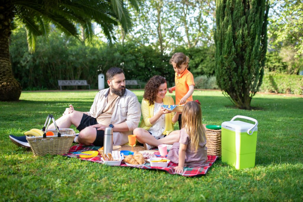 Happy family with kids sitting together at a park, symbolizing life insurance protection and peace of mind.